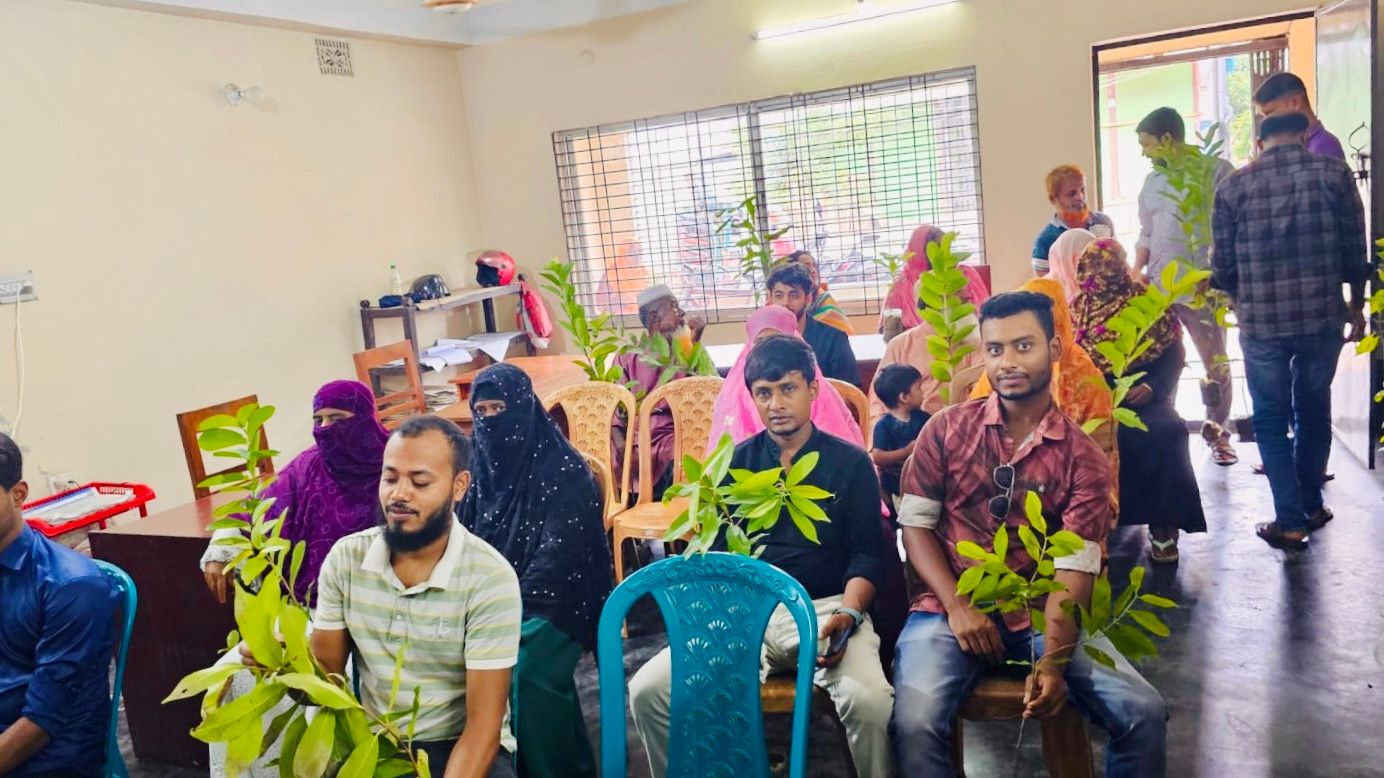 Community members seated with tree saplings distributed by FDF